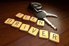 Teen driver in wooden letters with car keys on wooden desk