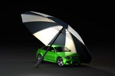 Car insurance protection concept with green car and umbrella on dark background