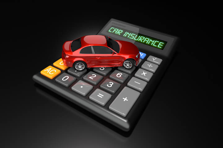 Red car sitting on calculator with LCD words Car Insurance