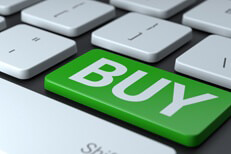 Laptop keyboard with large green Buy key to represent buying online