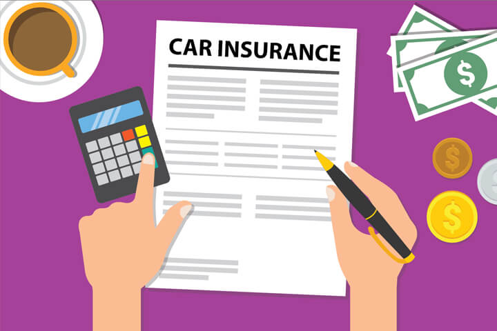 Desk with car insurance policy, coffee cup, money, and calculator with hand holding pen and touching key on calculator