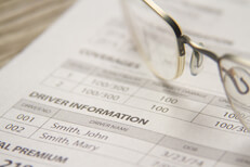 Car insurance policy billing notice with reading glasses