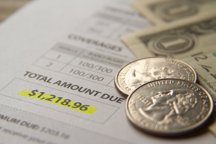 Car insurance billing notice with dollar bills and quarters