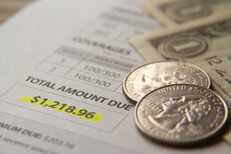 Car insurance cost Car insurance billing notice with dollar bills and quarters