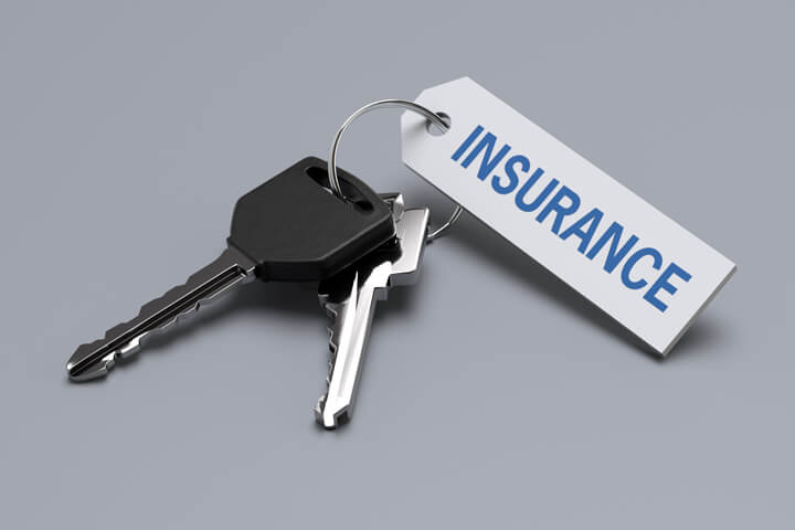 Car keys with insurance tag isolated on gray background