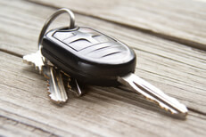 Car keys placed on weathered wood planks with soft shadows