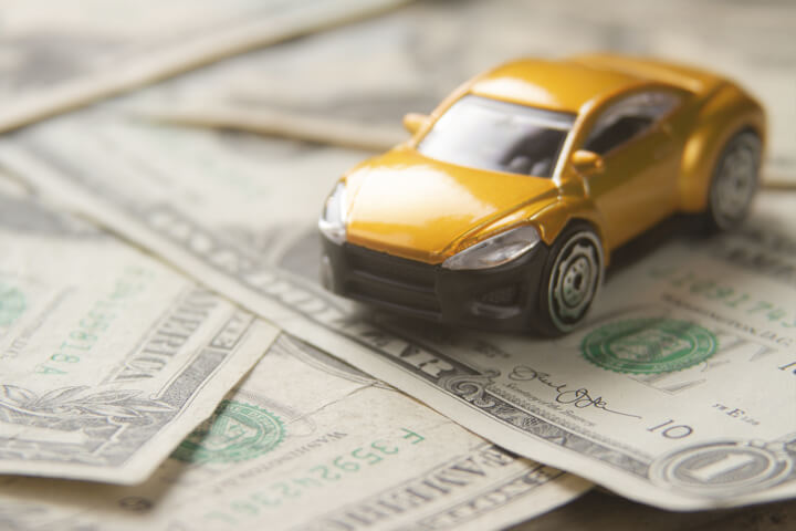 Small yellow car on randomly assorted one dollar bills