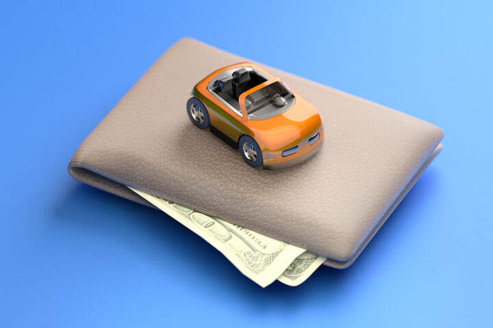 Toy car sitting on top of wallet with corners of bills sticking out from wallet blue background