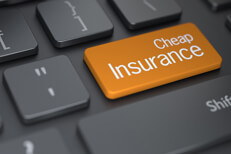 Laptop keyboard with large orange cheap insurance key concept for finding cheaper insurance online