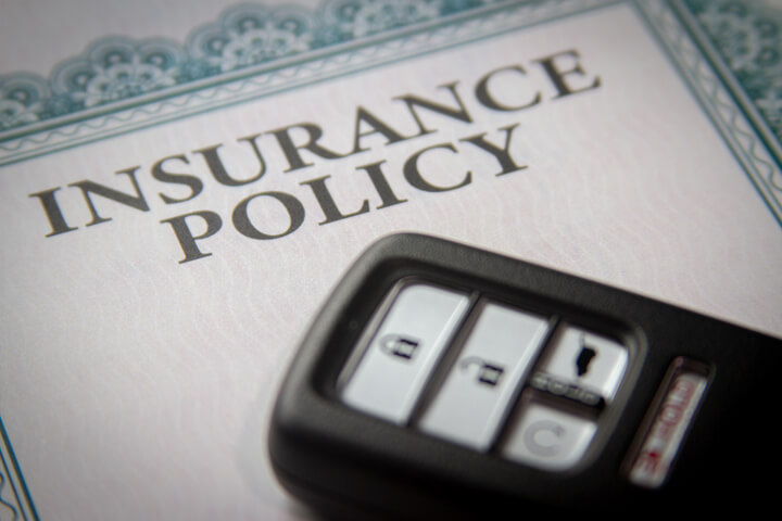 Photo of a vehicle keyless entry remote on an insurance policy certificate
