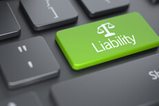 Dark laptop keyboard with green Liability key with legal scale icon concept for finding or researching liability insurance online