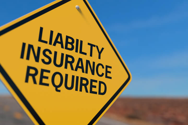 Yellow road sign reading Liability Insurance Required symbolizing mandatory state insurance liability laws