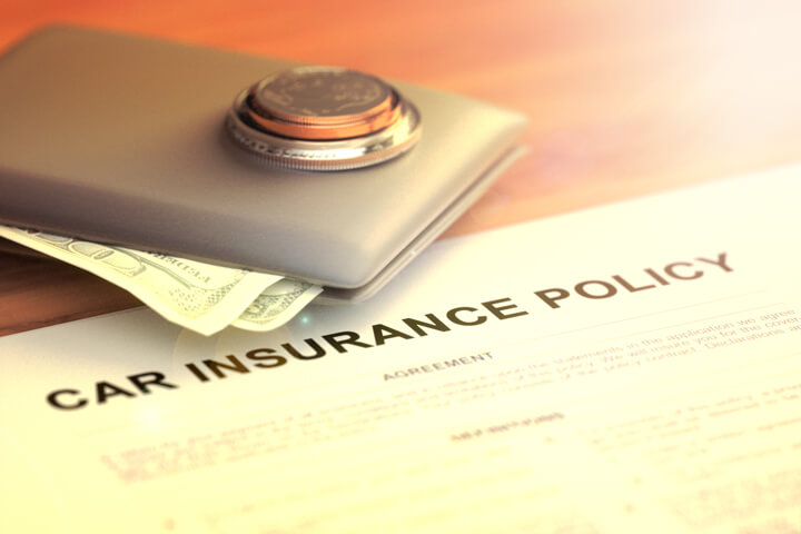 Wallet with coins and cash on car insurance policy with light flare and overlay effect