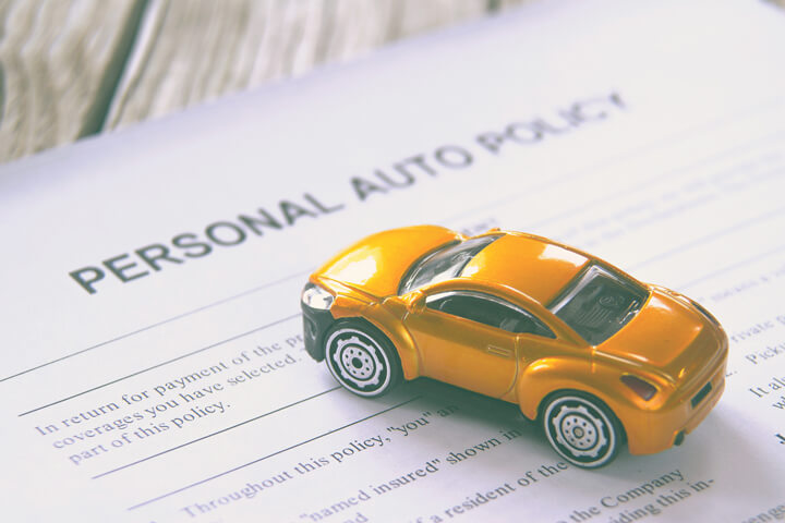 Personal auto insurance policy with small toy car