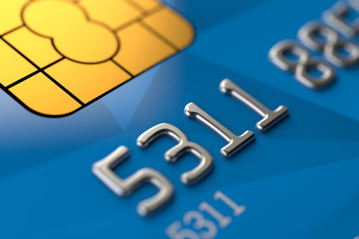 Close up photo of blue credit card with focus on EMV chip