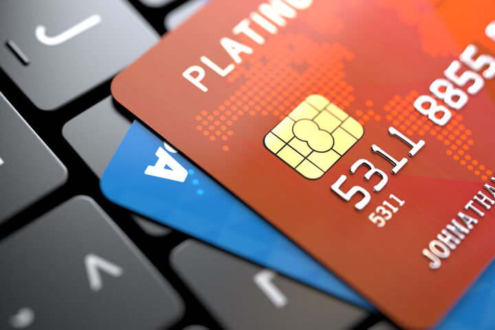 Two credit cards on dark laptop keyboard at angle concept for online purchase or credit report