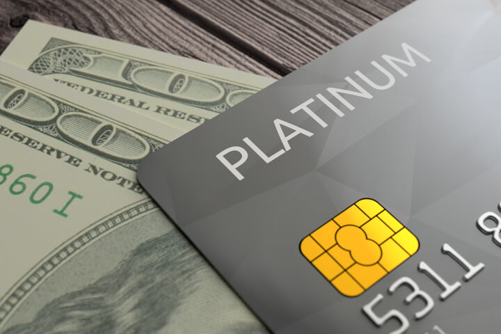 Photo of credit card with EMV chip resting on top of two one hundred dollar bills