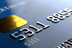 Close up view of credit card from corner angle showing partial number and EMV chip