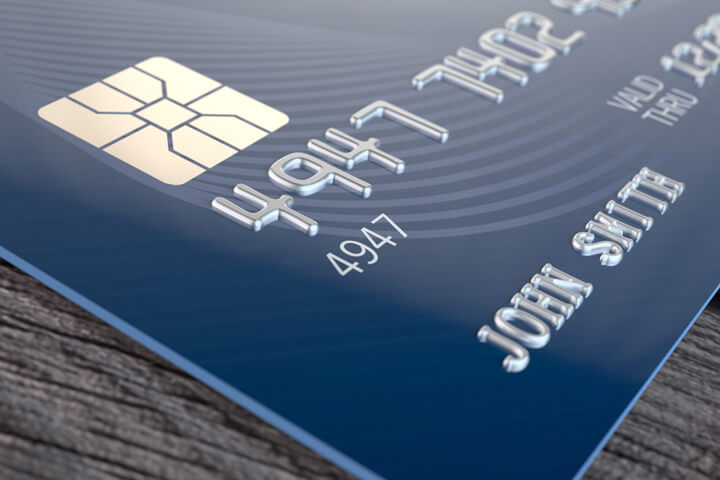 Blue credit card on wood background photo from corner close up