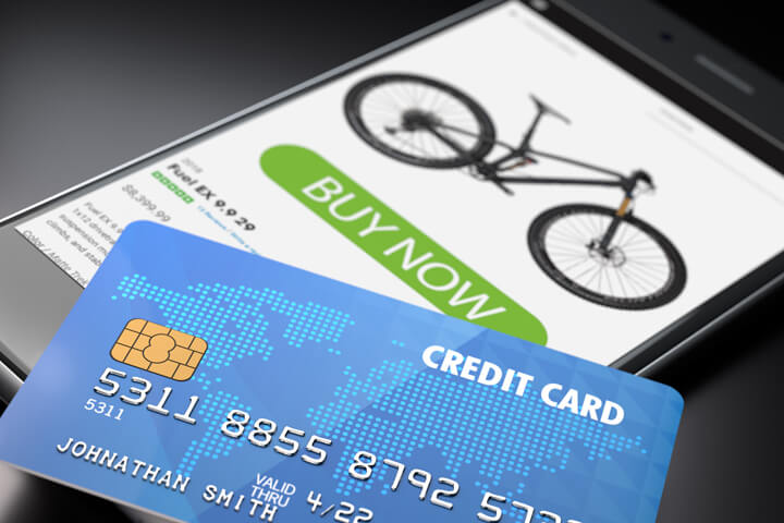 iPhone showing buy now button with blue credit card lying on screen