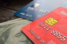 Credit cards or cash Two credit cards lying on two one hundred dollar bills