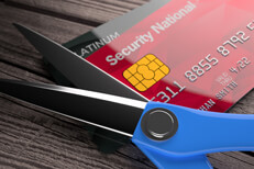 Two credit cards with scissors on weathered wood background