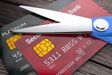 Two credit cards on weathered wood planks with scissors