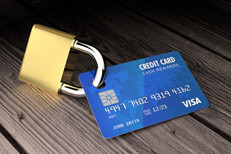 Blue credit card locked to padlock on weathered wood surface