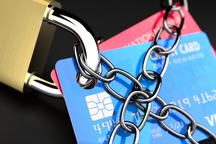 Close up photo of chains wrapping credit cards with padlock
