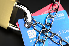Close up photo of chains wrapping credit cards with padlock