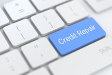 White laptop keyboard keys with blue credit repair key