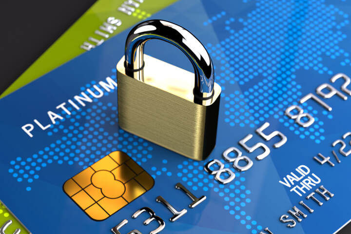 Two angled credit cards on dark background with small padlock on top