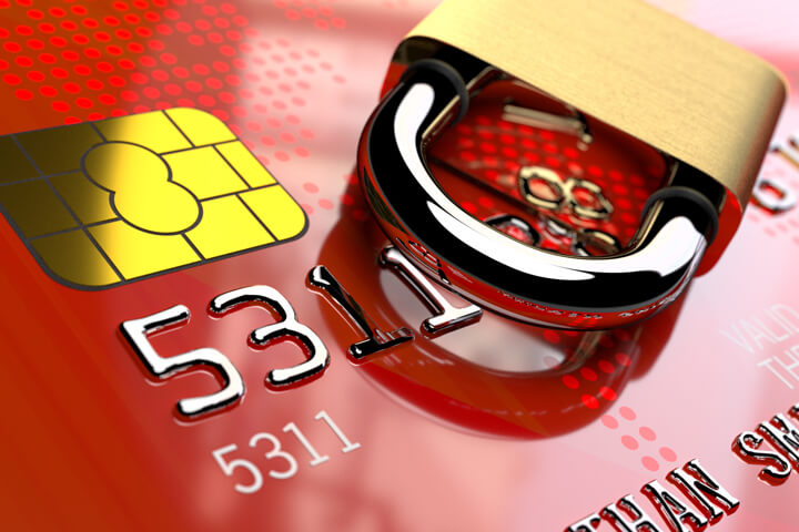 Angled view of red credit card EMV chip with padlock lying on side
