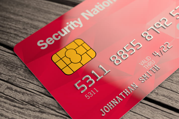 Red credit card lying on wood plank background
