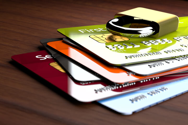 Stack of shiny credit cards with small padlock on top