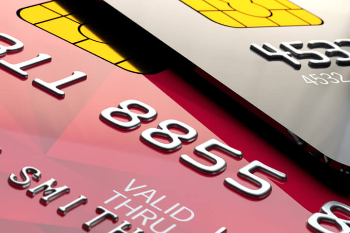 Close up view of shiny red and black credit cards with EMV chips