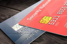 Angled view of Mastercard and Visa credit cards on wood surface