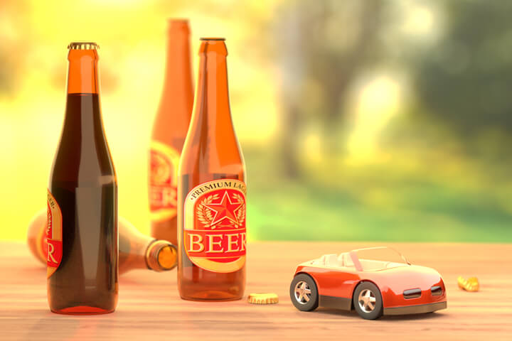 Beer bottles on table outside with red toy car concept for driving under the influence or drunk driving