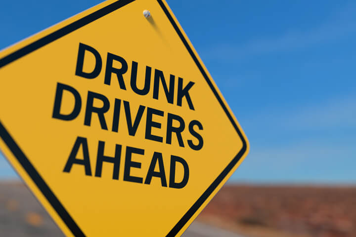 Yellow road sign reading Drunk Drivers Ahead DUI concept image