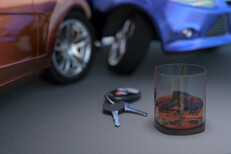 Side impact collision resulting from drunk driving concept with whiskey glass and car keys in foreground