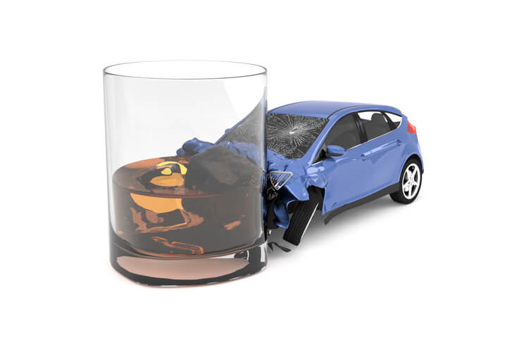 Drunk driving concept showing compact car crashed into glass of whiskey isolated on white background