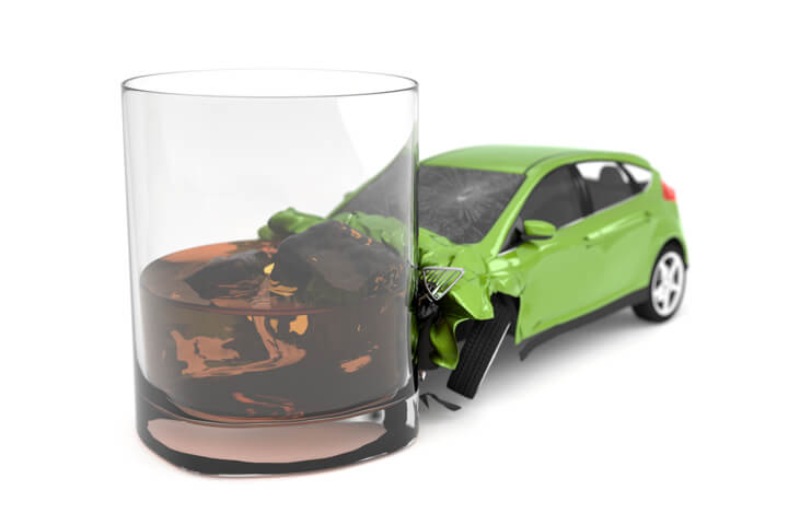 Drunk driving concept of small green car collision with alcoholic drink isolated on white background