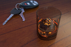 Drunk driving concept with whiskey glass next to car keys on bar