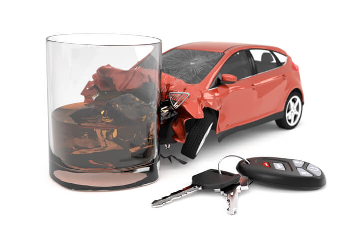 Driving impaired concept of car crashed into glass of scotch with keys and key fob