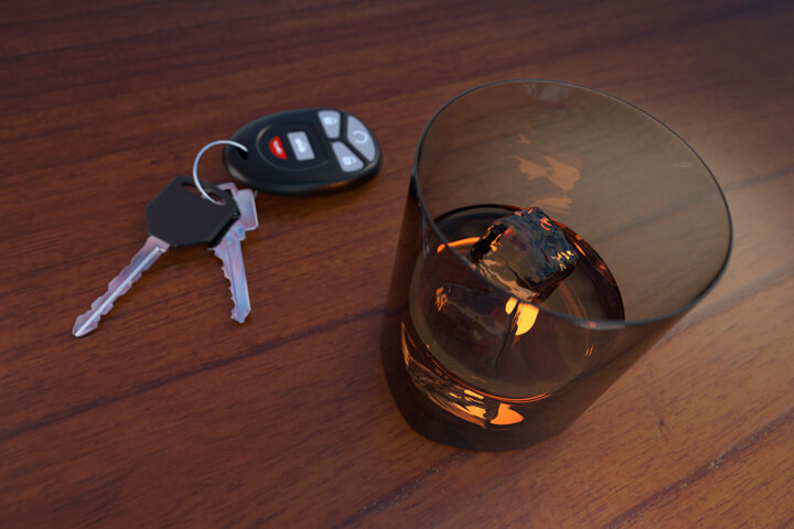 Drunk driving concept showing a glass of whiskey and car keys sitting on a bar