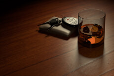 Drunk driving concept showing a whiskey glass on bar with wallet and car keys
