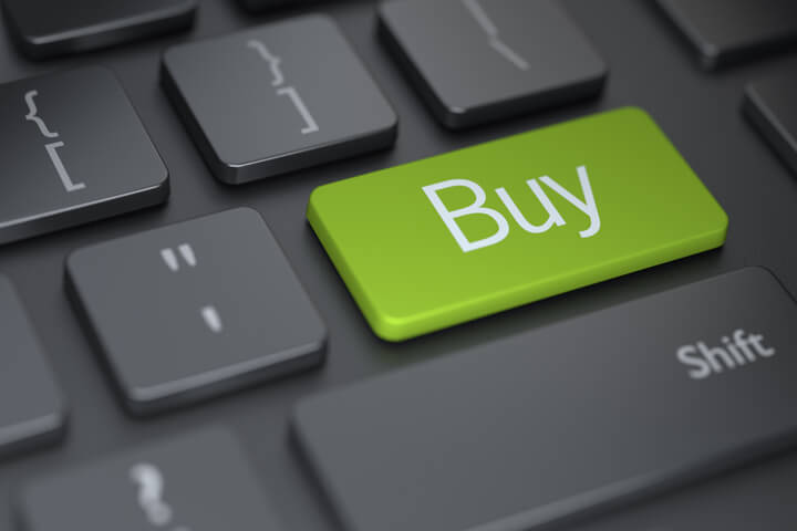 Dark computer keyboard with large green Buy button representing online shopping or buying online