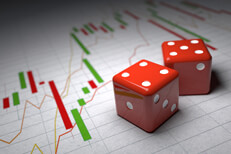 Concept of speculation risk showing red dice on candlestick and line charts for stock and market prices