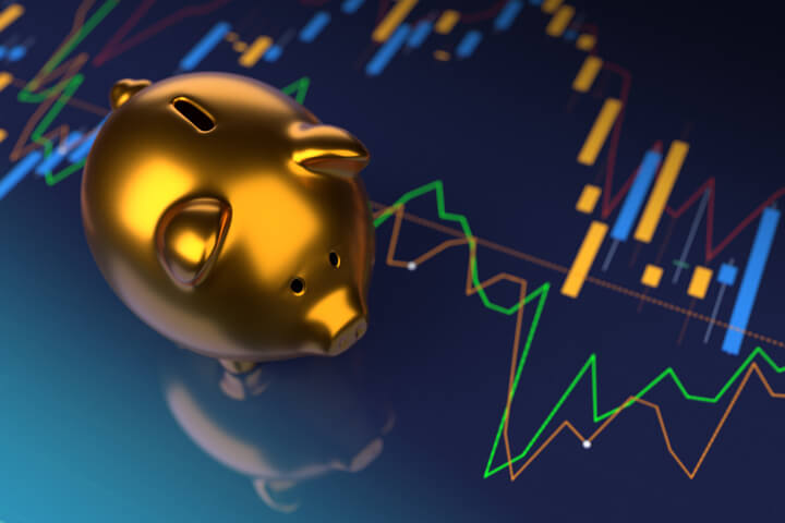 Shiny gold piggy bank on stock price charts representing investments
