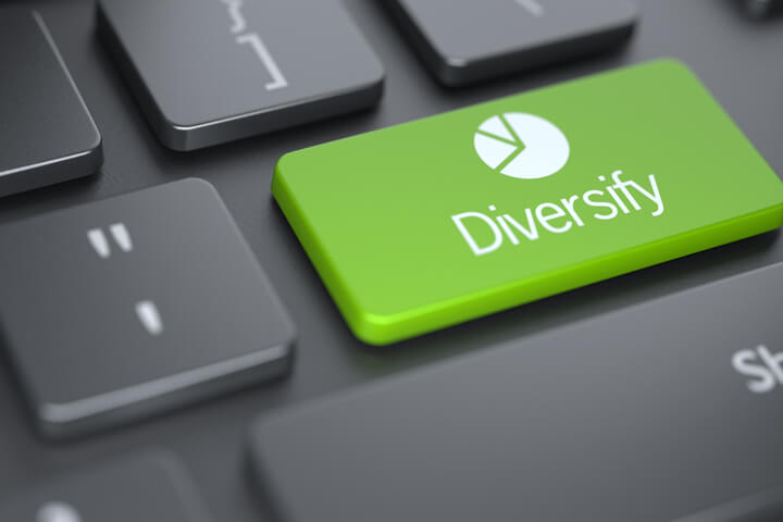 Dark laptop keyboard with large green Diversify key with pie chart icon